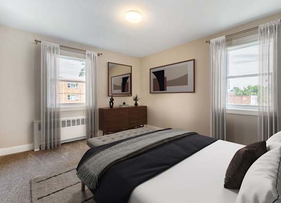 A bedroom with a large bed and a window with curtains.