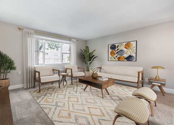 A living room with a rug, a couch, a chair, a coffee table, and a potted plant.