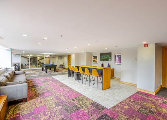 A large room with a pink carpet and a long table with chairs.