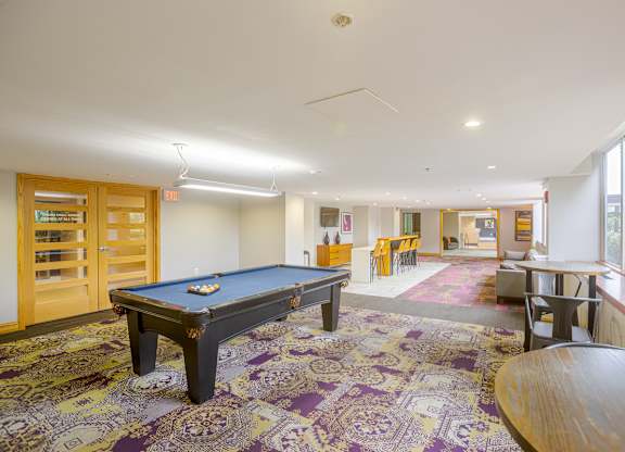 A pool table in a room with a purple carpet.