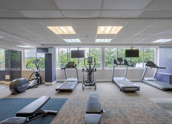 A gym with treadmills, exercise bikes, and elliptical machines.