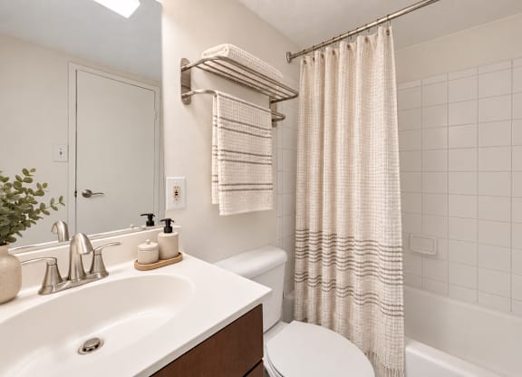 A white bathroom with a toilet, sink, and bathtub.