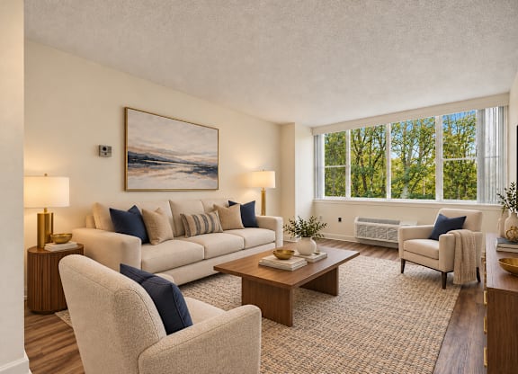 A living room with a large painting on the wall and a couch with blue pillows.