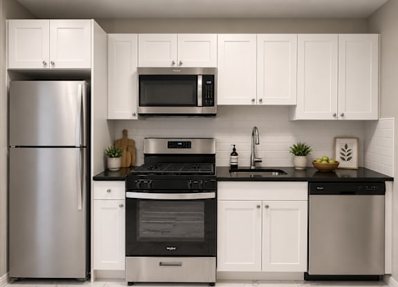 A modern kitchen with a stainless steel refrigerator, black countertops, and white cabinets.