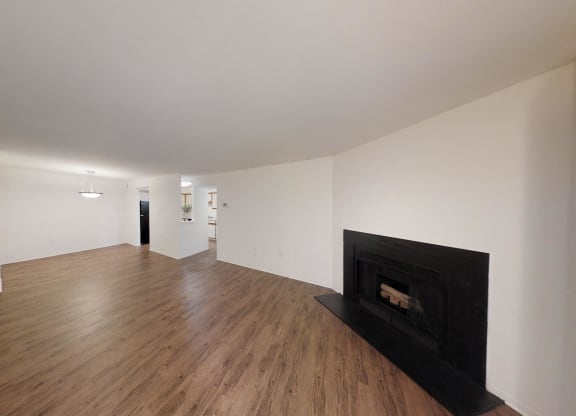 a living room with a black fireplace and wooden floors