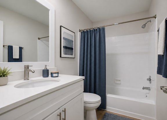 A bathroom with a white sink and a white toilet.