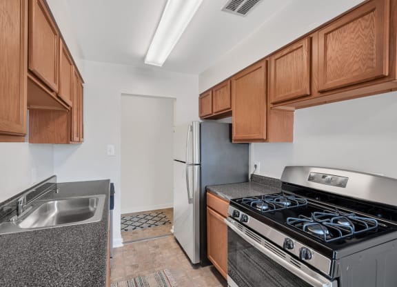 a kitchen with wood cabinets and stainless steel appliances