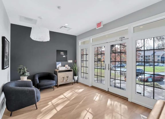 a living room with two chairs and a door to the street
