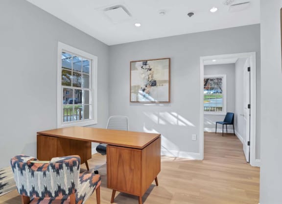 a home office with a wooden desk and chairs