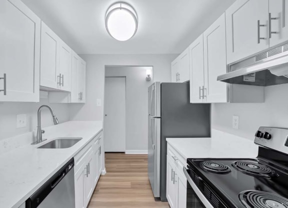 a white kitchen with a stove and a refrigerator