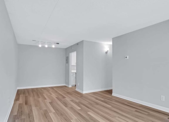 the living room and dining room of an empty house with wood floors