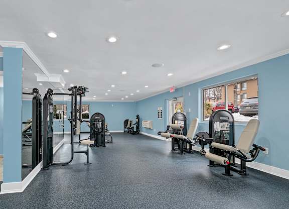 A gym with a row of chairs and a row of exercise machines.
