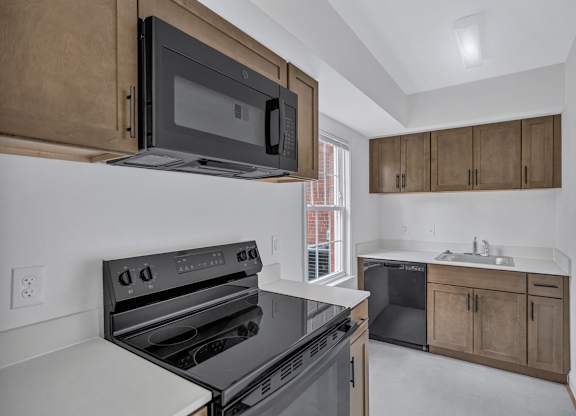 A modern kitchen with a black microwave above the stove.