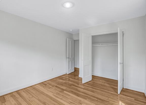 A room with wooden flooring and white walls.