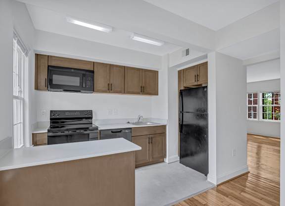 A kitchen with a white counter top and wooden cabinets.