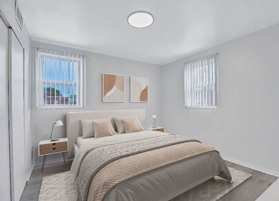 A bedroom with a large bed and a window with blinds.