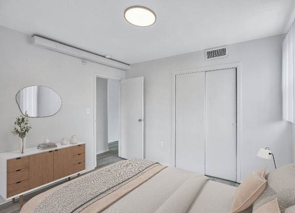 A bedroom with a bed, dresser, and mirror.