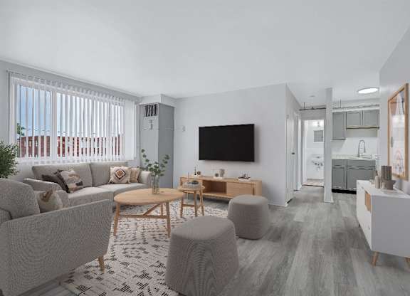 A modern living room with a grey sofa, a wooden coffee table, and a TV mounted on the wall.