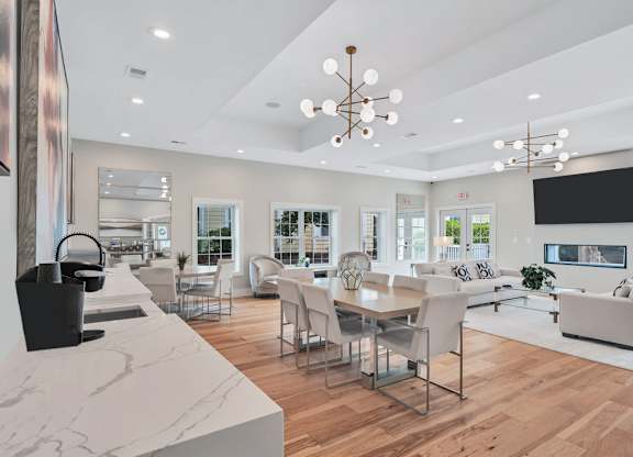 a clubroom with white sofas, a dinette, and are on the walls.