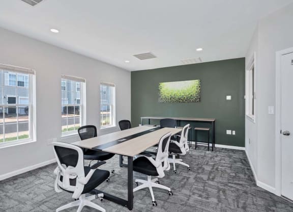 a conference room with a table and chairs and a tv on the wall