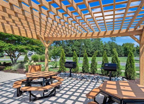 a wooden pergola with benches and tables
