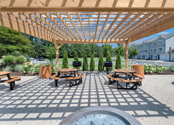a picnic area with a grill and picnic tables