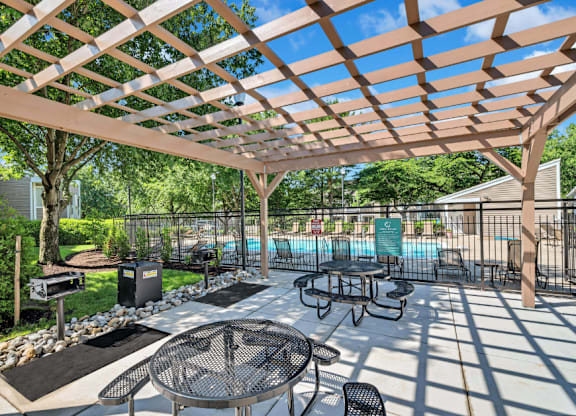 a patio with tables and chairs and a pool
