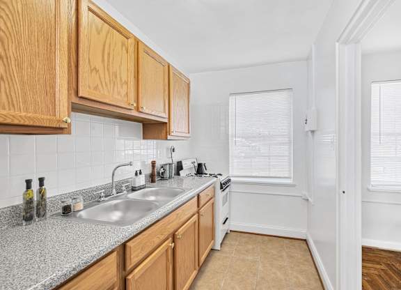 A kitchen with wooden cabinets and a granite countertop.