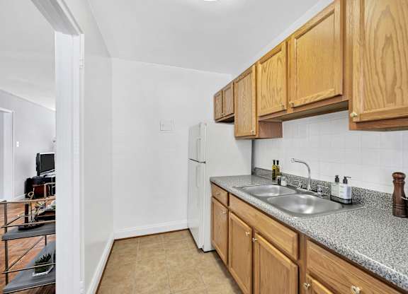 A kitchen with wooden cabinets and a granite countertop.