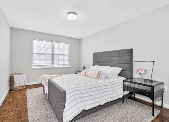 A bedroom with a large bed and a painting on the wall.