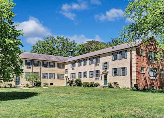 A large building with a green lawn in front.