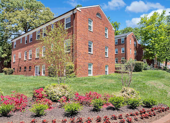 A red brick building with a garden in front.
