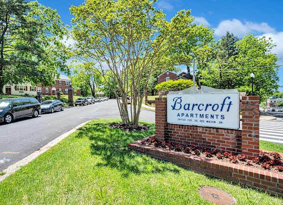 A sign for Barcroft Apartments is in front of a grassy area.