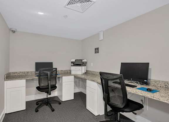 Two chairs and two desks in a small office.