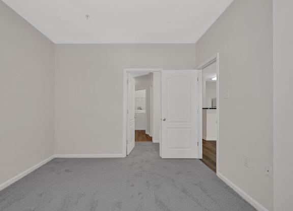 A room with a carpeted floor and a white door.