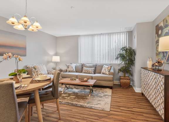 A well-lit living room with a dining table and chairs.