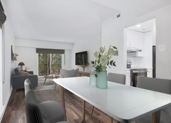 a living room with a white table with a vase of flowers