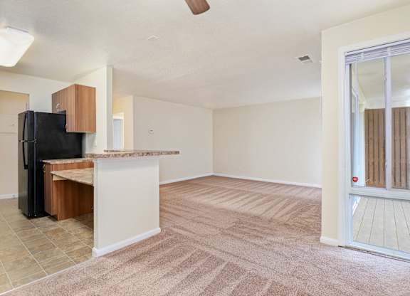 an empty living room and kitchen with a sliding glass door