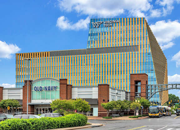 A modern building with a glass facade and a sign that reads