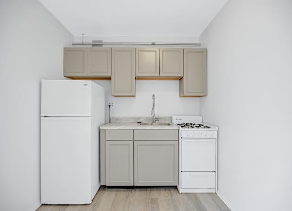 A small kitchen with a white refrigerator, a white dishwasher, and a sink.