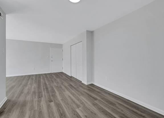 A room with wood flooring and white walls.