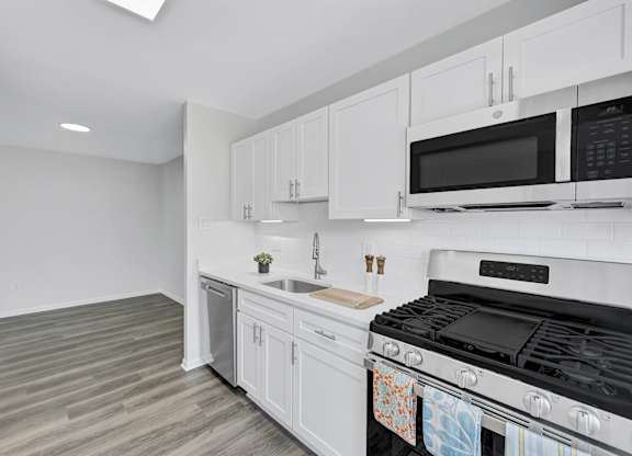 A kitchen with white cabinets and appliances.