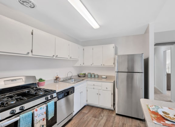 a kitchen with white cabinets and stainless steel appliances