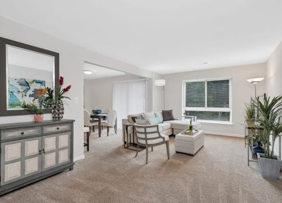 a living room with beige carpet and a white couch