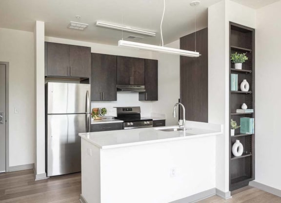 a kitchen with a white counter top and a refrigerator