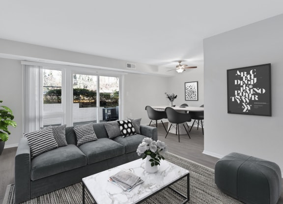 an open living room with a gray couch and a coffee table
