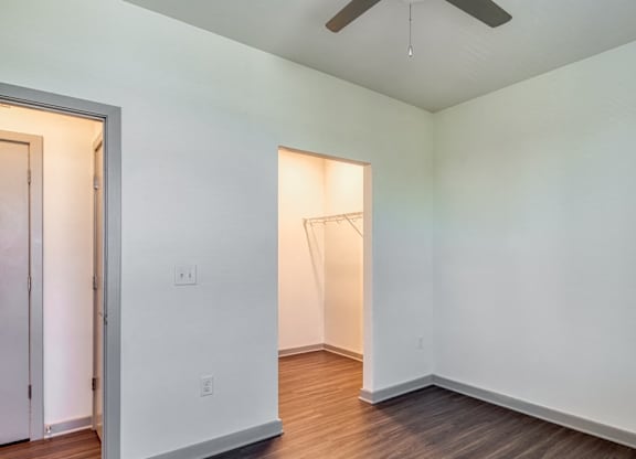 a room with white walls and wood floors and a closet