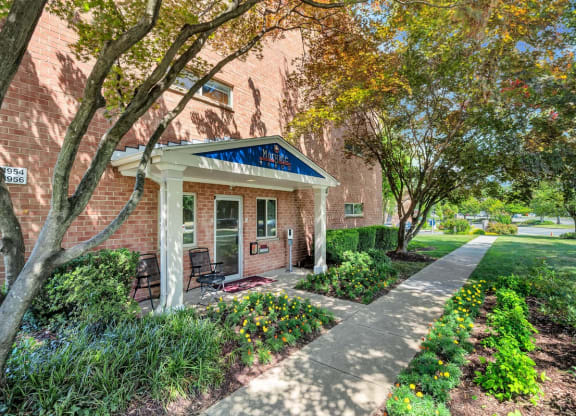 a brick building with a blue awning and a sidewalk in front of it