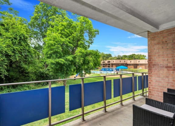 a balcony with a blue fence and a pool in the background