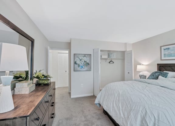 a bedroom with a large bed and a dresser with a mirror